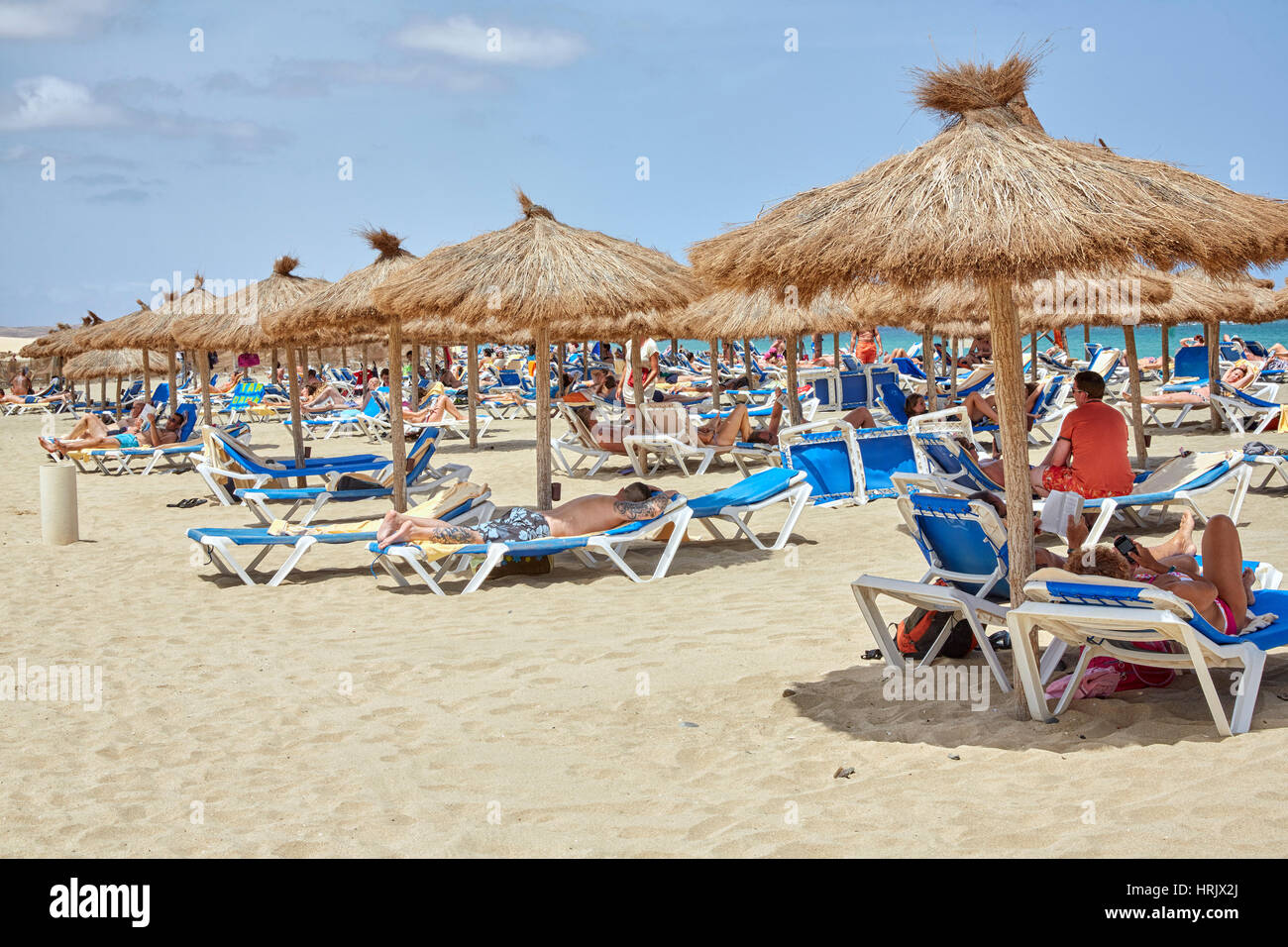 Touristen entspannen unter reetgedeckten Tiki Sonnenschirme im Riu Karamboa Resort, Boa Vista, Kap Verde (Cabo Verde), Afrika Stockfoto