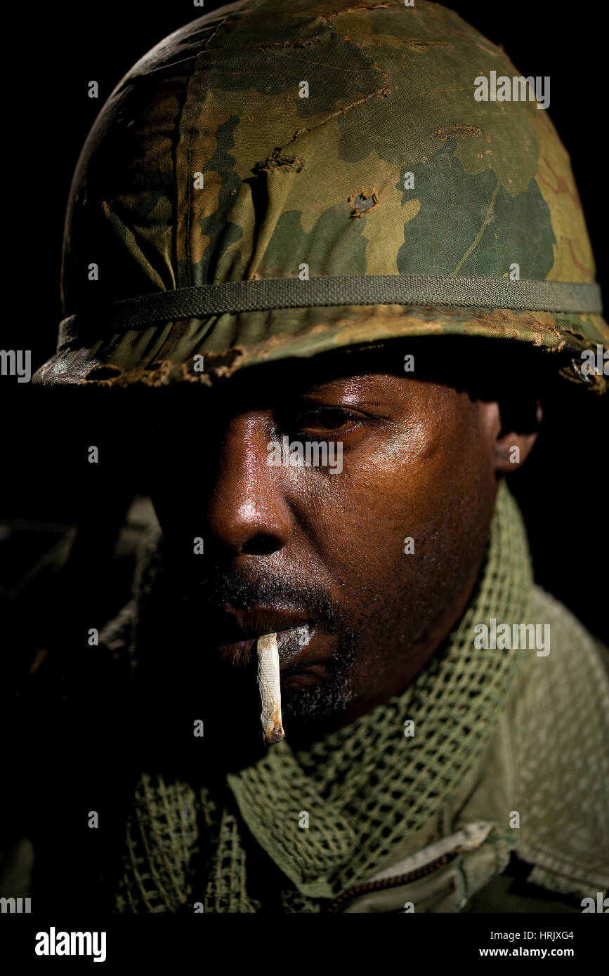 Porträt des afroamerikanischen Soldaten aus der Zeit des Vietnam-Krieges vor einem schwarzen Hintergrund. Dunkle Schatten für ein dramatischer Bild verwendet. Stockfoto