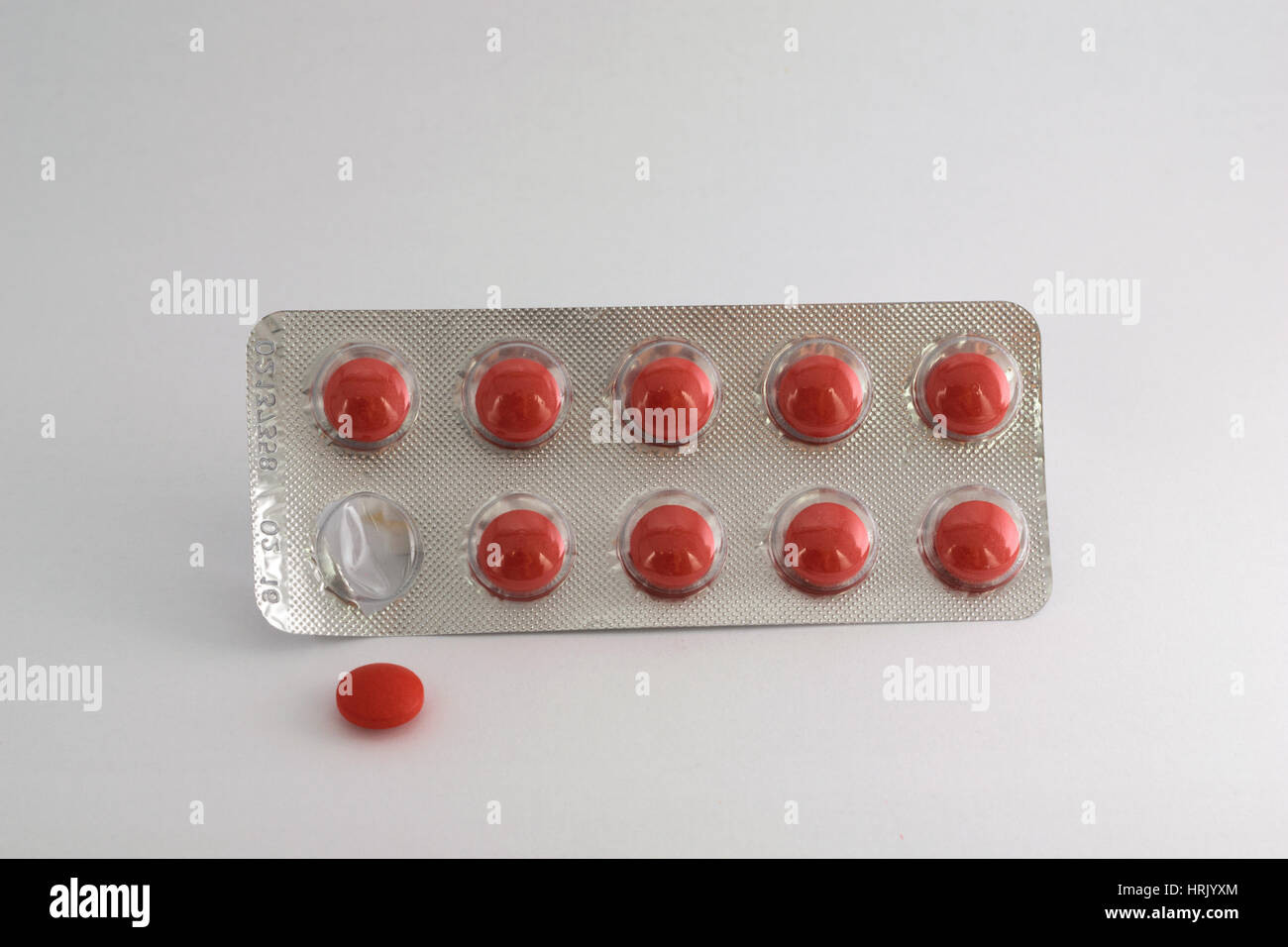 Rote Tabletten Blister isoliert. Eine Pille wird von Tha Pack entfernt. Stockfoto