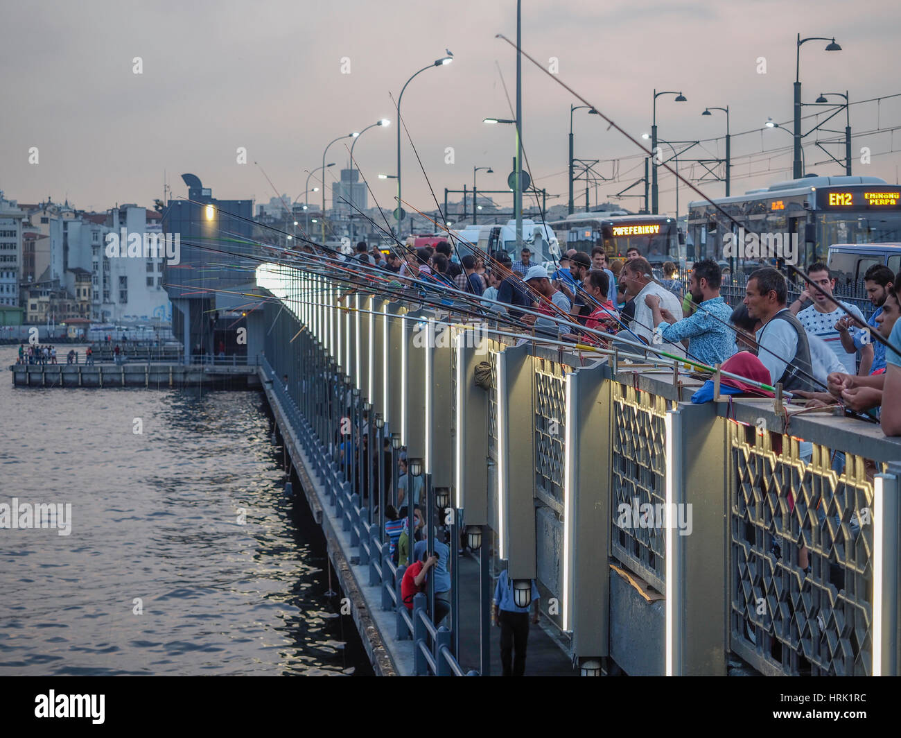 FISCHER MIT STAB UND LINIE ANGELN VOM GALATA-BRÜCKE BEI ABENDDÄMMERUNG ISTANBUL TÜRKEI Stockfoto