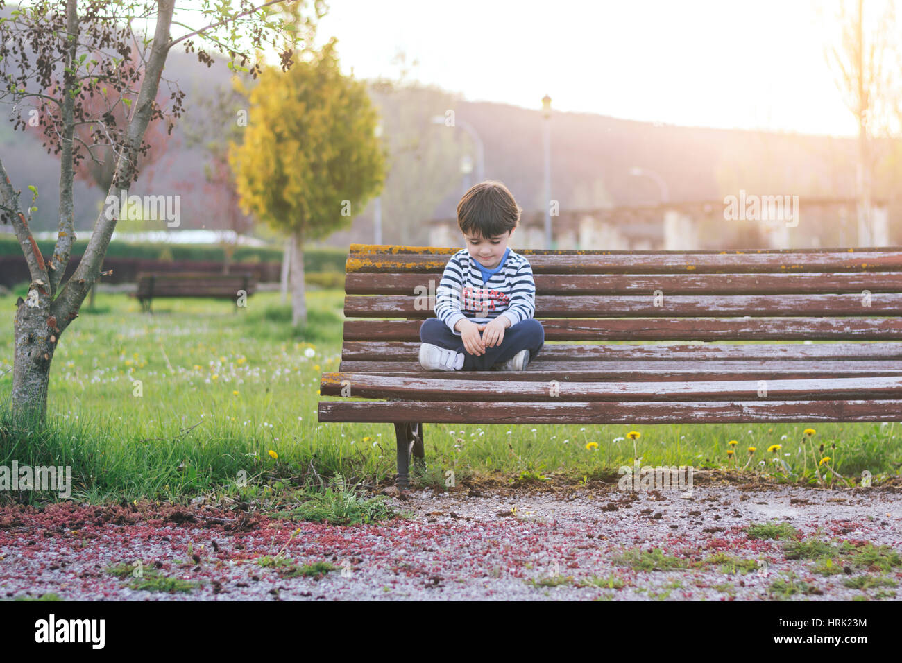 Traurige Junge sitzt im park Stockfoto