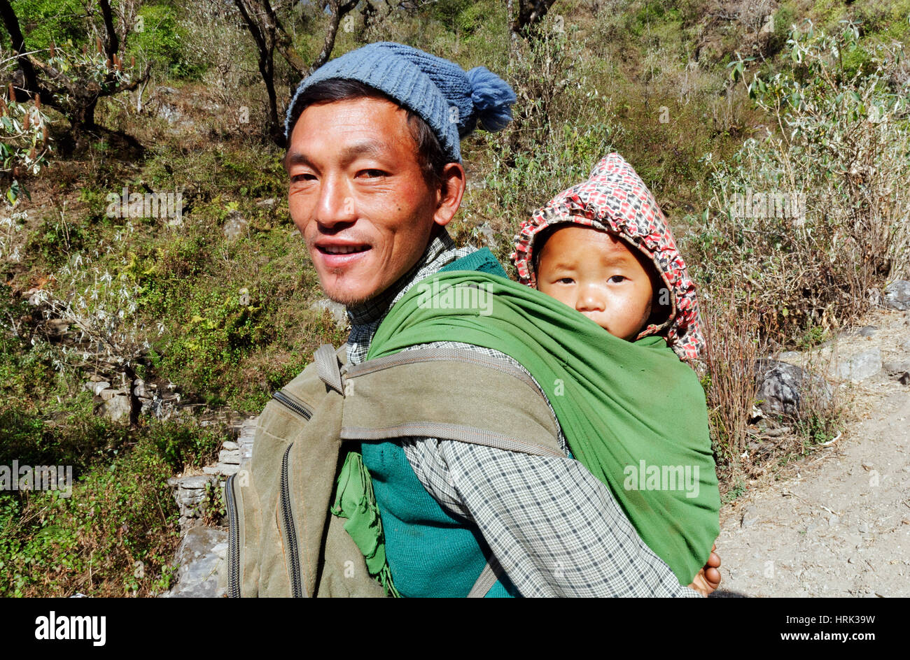 Eine nepalesische Mann trägt sein Baby in einer Kindertrage Rucksack Stockfoto