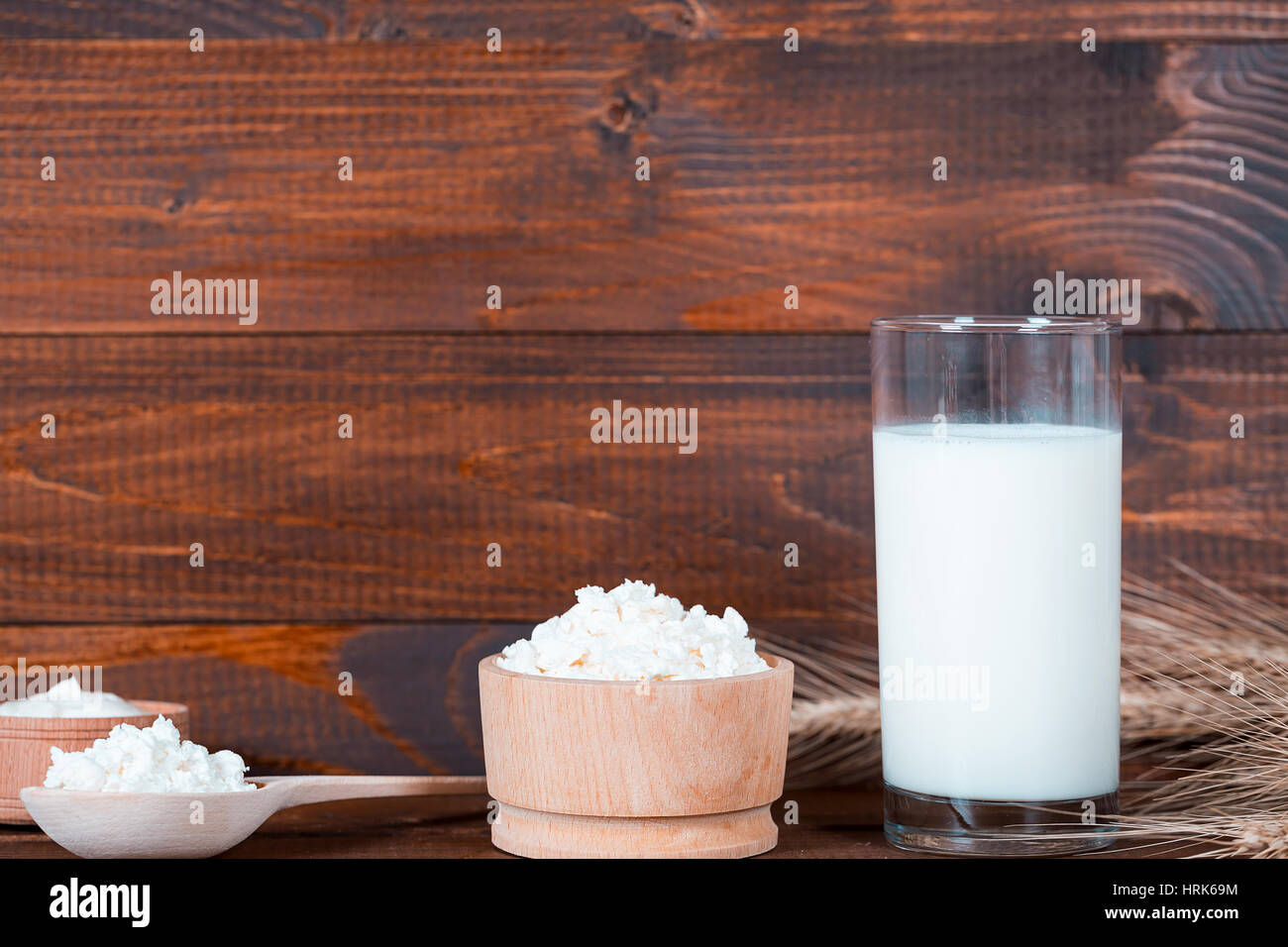 Hausgemachte Naturprodukte: Milch, Käse, saurer Sahne und Eiern auf alten hölzernen Hintergrund mit Ähren. Mit Platz für Ihren text Stockfoto