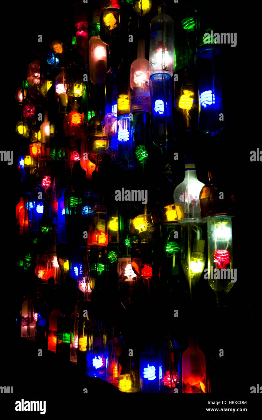 Flasche Lichter in der Nacht. Farbige Glühbirnen in alten Alkoholflaschen. Stockfoto