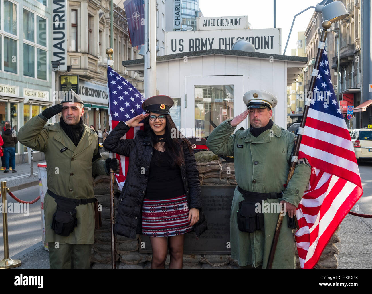 Touristen posieren mit amerikanischen Soldaten am Checkpoint Charlie in Berlin, Deutschland Stockfoto