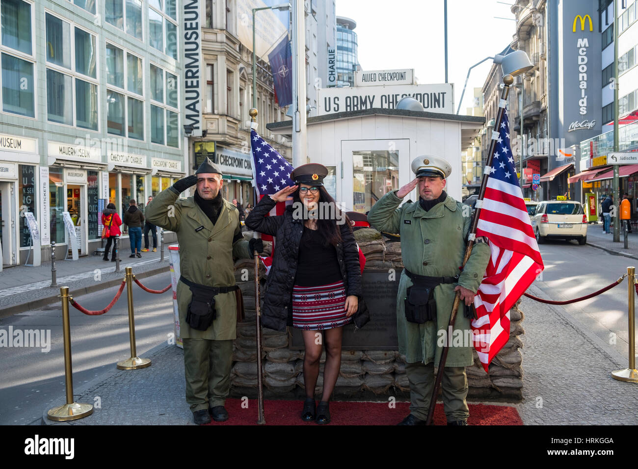 Touristen posieren mit amerikanischen Soldaten am Checkpoint Charlie in Berlin, Deutschland Stockfoto