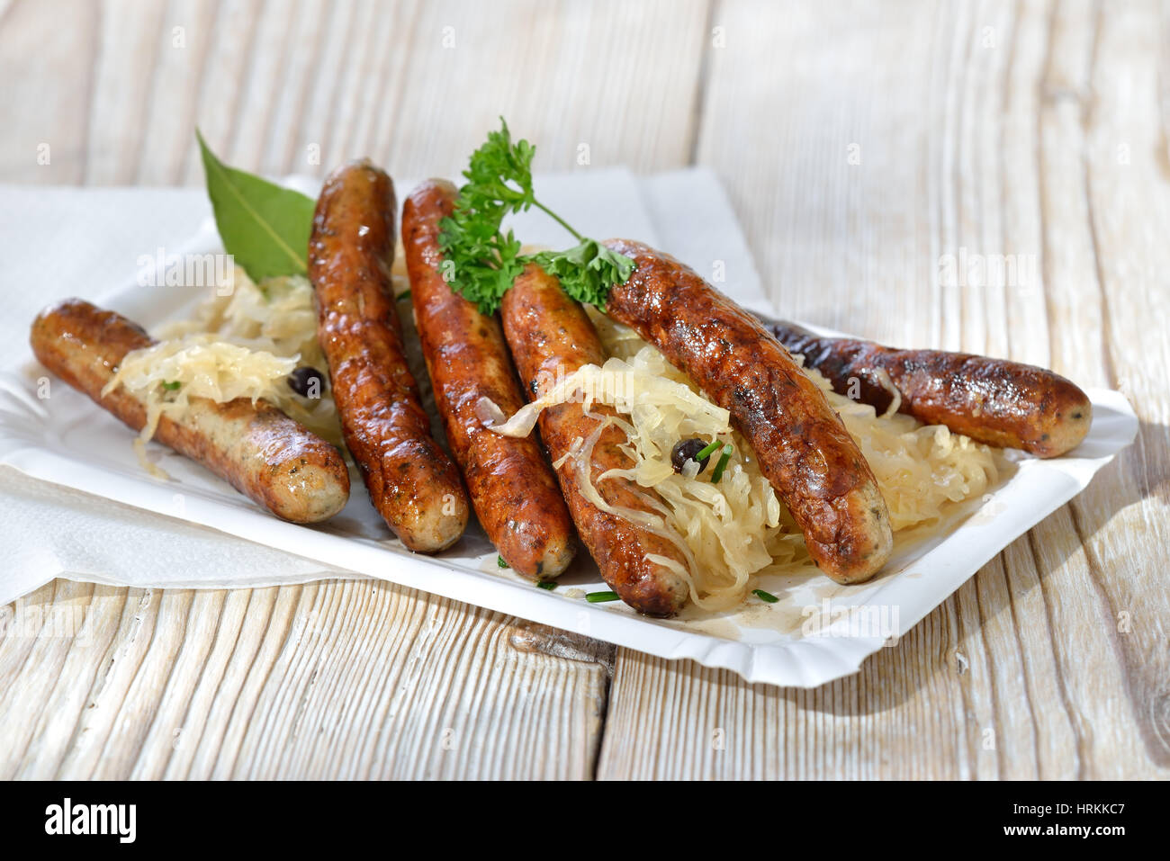 Sechs bayerische Würstchen aus Nürnberg, serviert mit Sauerkraut auf ...