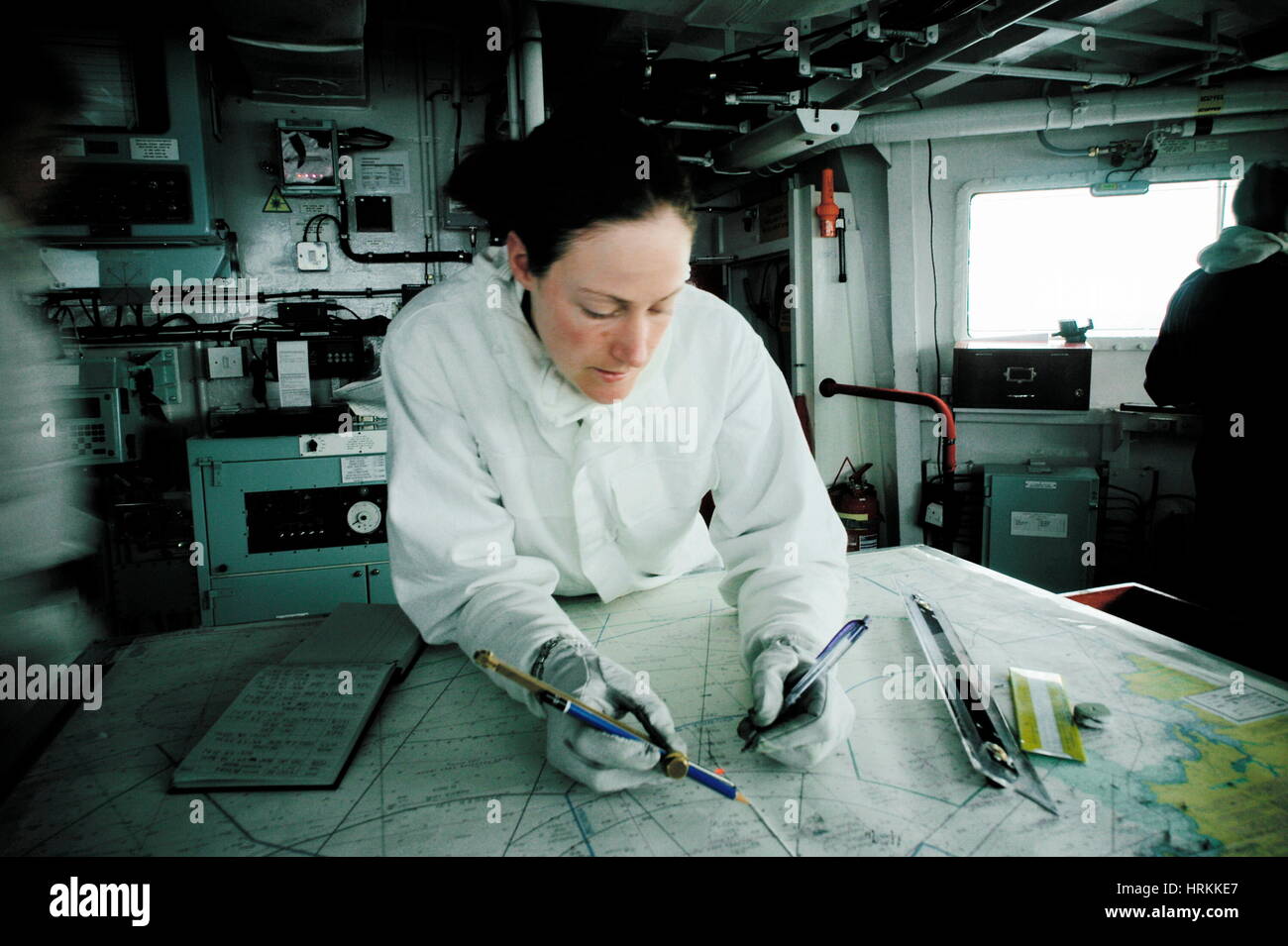 AJAXNETPHOTO.2005.AT MEER, BRITISCHEN TERRITORIALEN GEWÄSSERN. -KÖNIGLICHE MARINE TYP 23 DUKE-KLASSE FREGATTE HMS KENT - WARFARE OFFICER CHANTAL STRAWBRIDGE (24) PRÜFT SCHIFFSPOSITION GEGEN PROJIZIERTEN ROTEN GPS-SIGNAL MIT TRADITIONELLEN NAVIGATOR WERKZEUGE UND FLIPCHART.  FOTO: JONATHAN EASTLAND/AJAX REF: R50410 / 771 Stockfoto