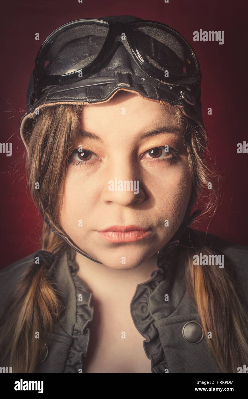 Mädchen mit Flieger Hut und Brille macht dummen Gesichtsausdruck von starkem wind Stockfoto