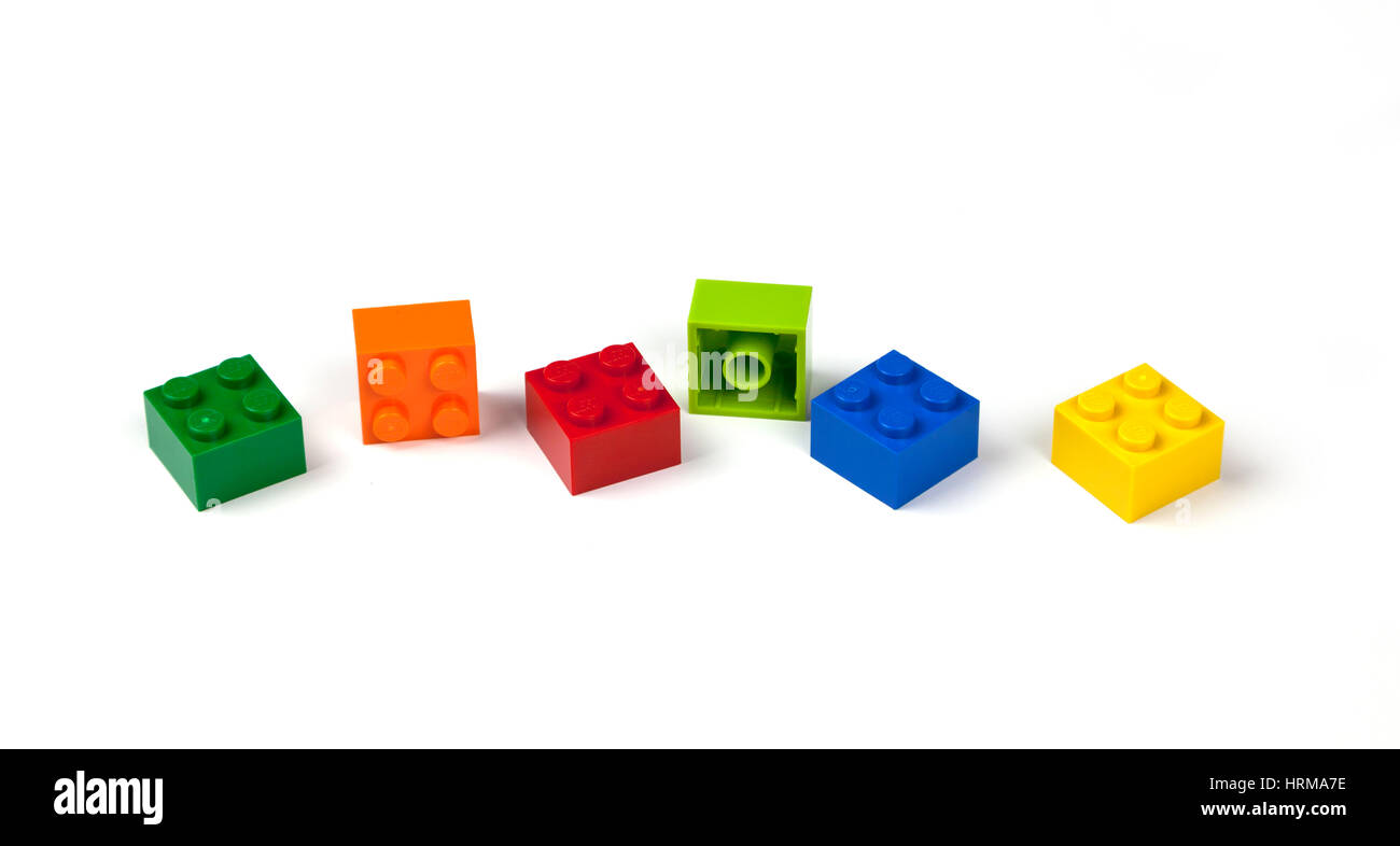 Grün, orange, rot, blau, gelb Lego Ziegelsteine oder Stücke 2 x 2, 2 x 2 auf weiß. Stockfoto