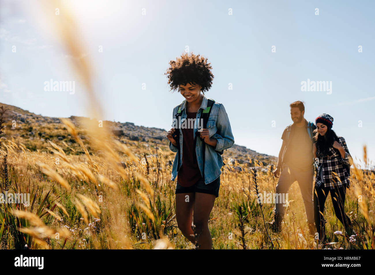 Gruppe von Personen in Landschaft wandern. Junge Frauen und Männer auf Bergtour. Stockfoto