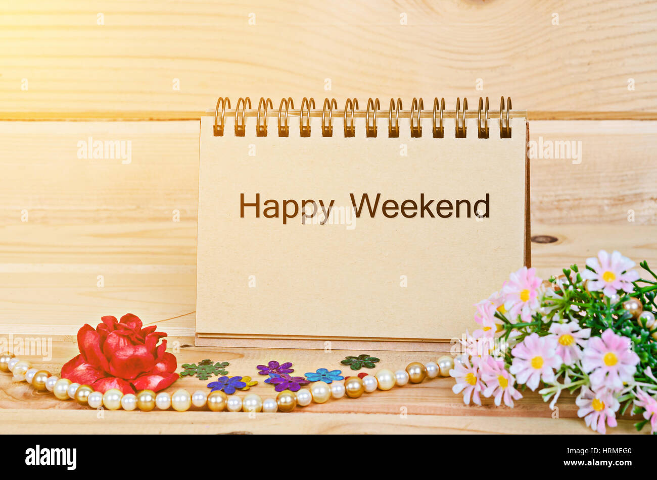 Happy Wochenende Text auf Briefbögen mit Blumen- und morgen Sonnenlicht im Raum aus Holz. Stockfoto