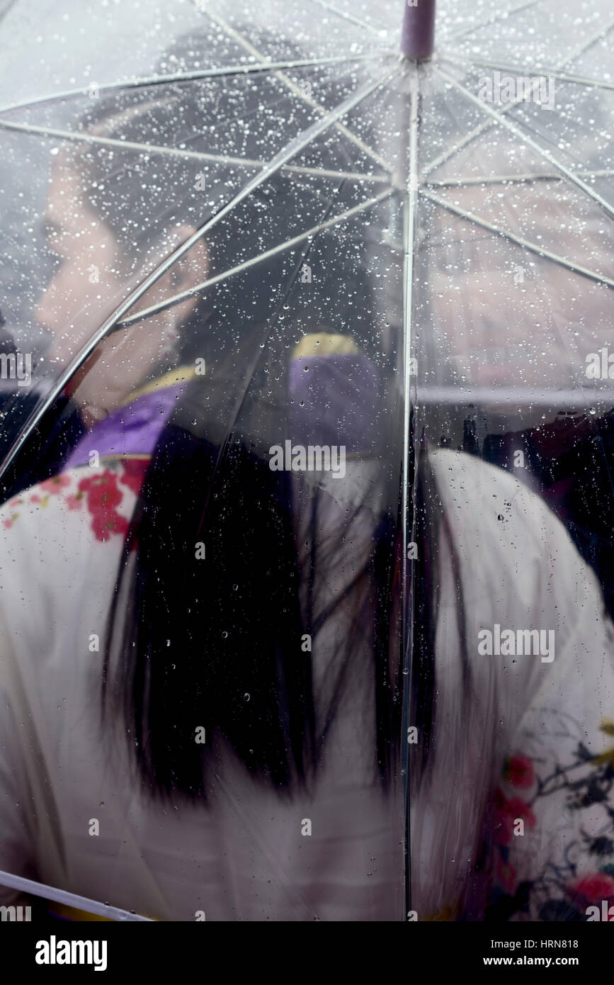 Mailand. Italien. Chinese New Year fest. Chinesisches Mädchen in traditioneller Kleidung im Regen bedeckt mit Regenschirm Stockfoto