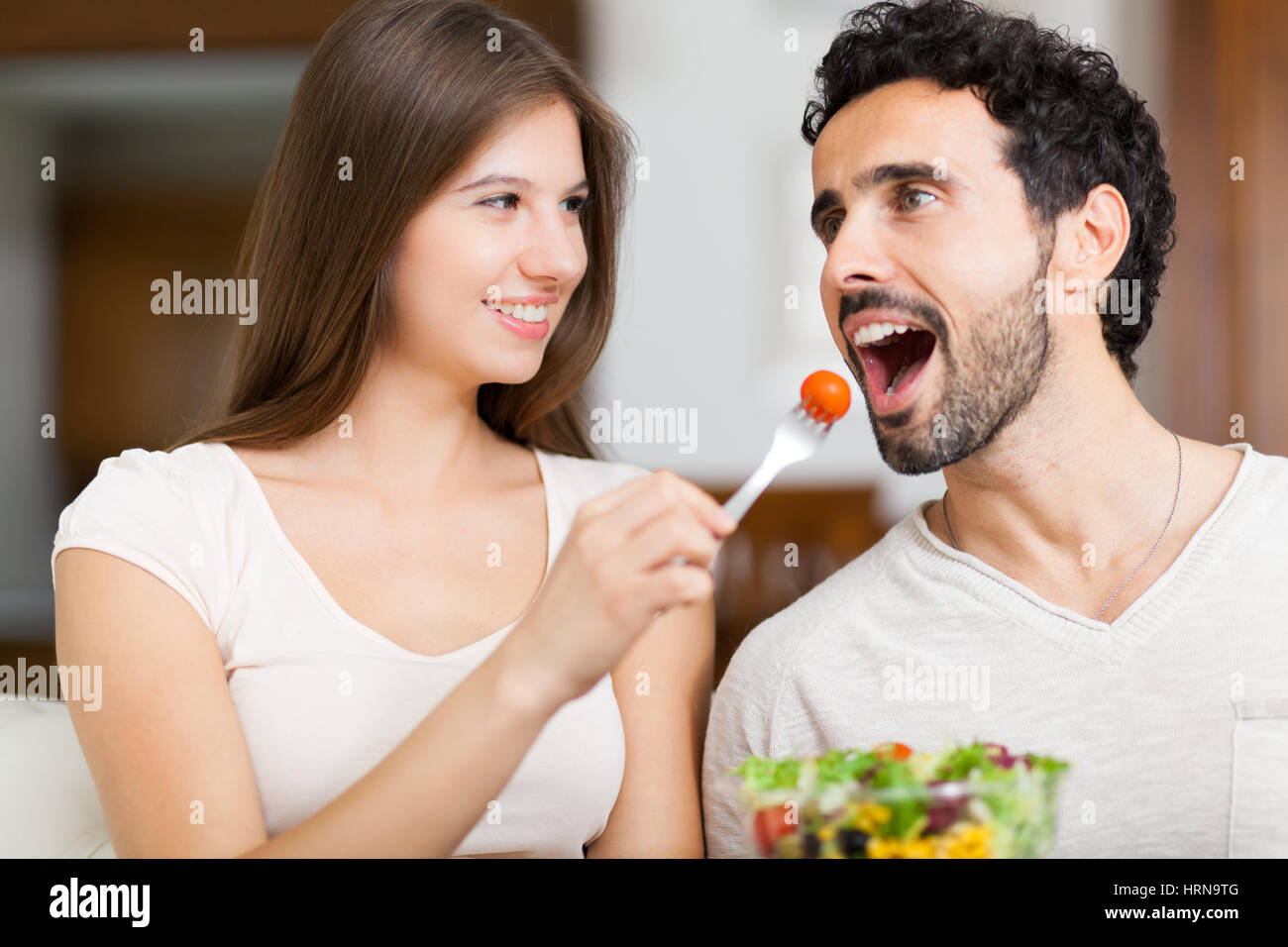 Paar essen Salat auf dem sofa Stockfoto