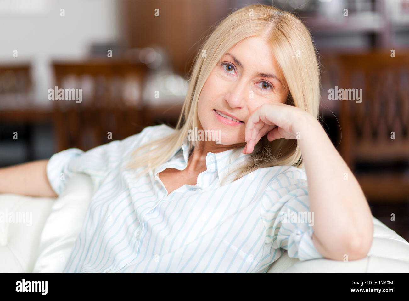 Senior Woman Relaxing On Sofa zu Hause Stockfoto