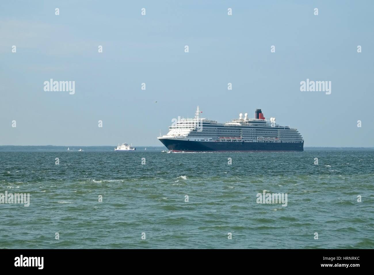 Das Kreuzfahrtschiff Cunard es MS Queen Victoria als es bestanden Fort Victoria Überschrift auf dem Solent in Richtung der Nadeln Verzwergung der Isle Of Wight Fähre. Stockfoto