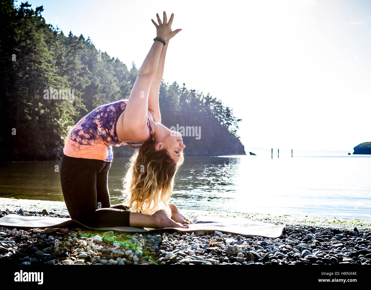 Eine Frau, Yoga in einer wunderschönen Umgebung im Freien zu praktizieren. Stockfoto