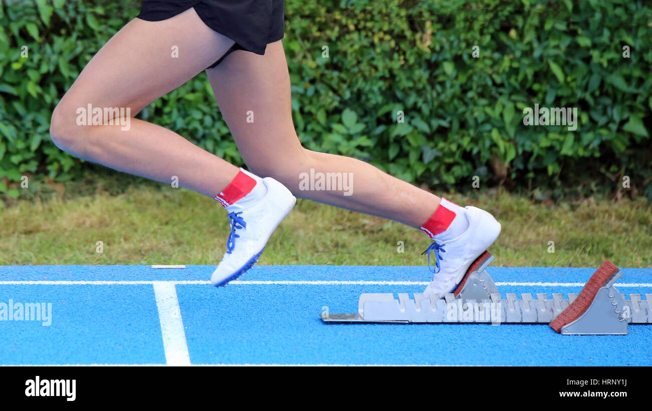 Junge Sportler startet vom Startblock ein Rennen in Leichtathletik Stockfoto