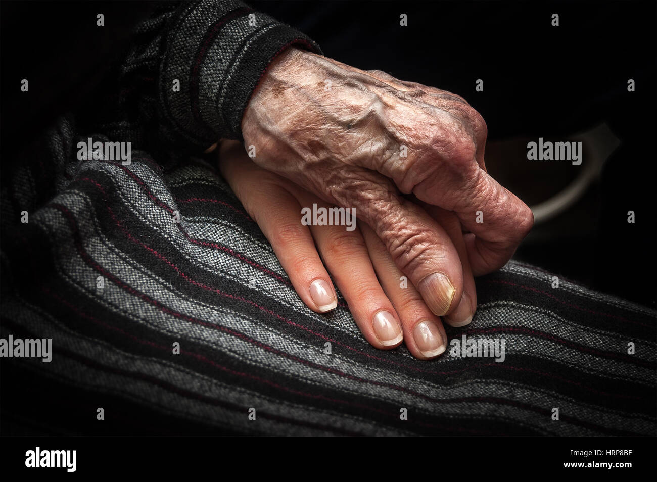 Faltige Haut Hand gealterte Frau an Hand der jungen Dame Stockfoto
