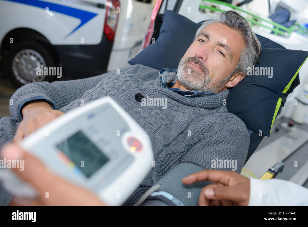 Mann in Bahre gelegt haben Blutdruck-test Stockfoto