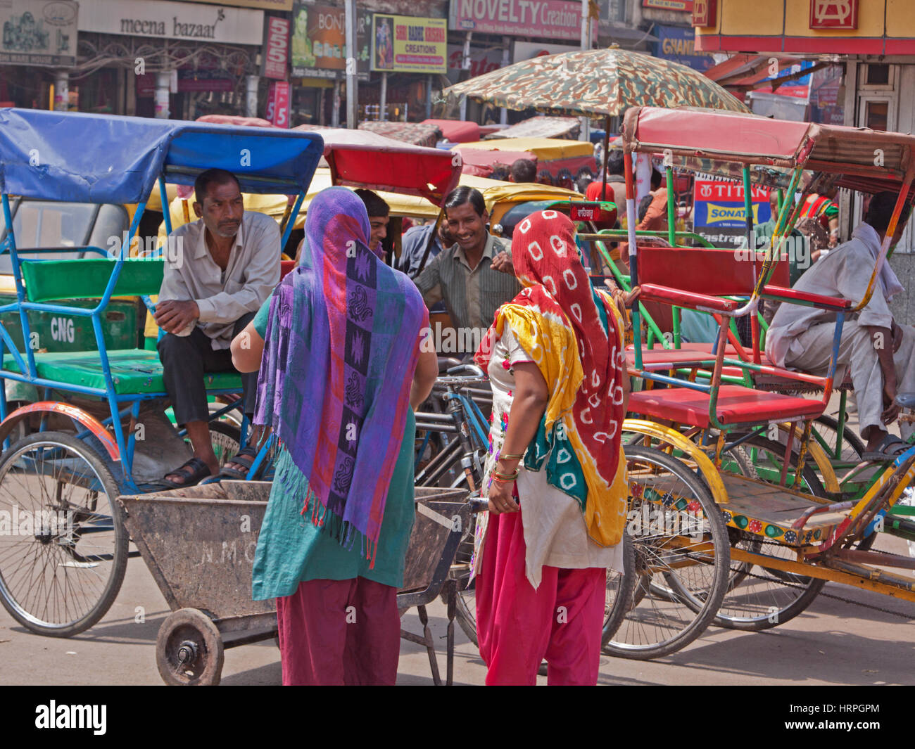 Besitzer von Fahrradrikschas im Gespräch mit potenziellen Kunden im Bereich Chandni Chowk von Alt-Delhi, Indien Stockfoto
