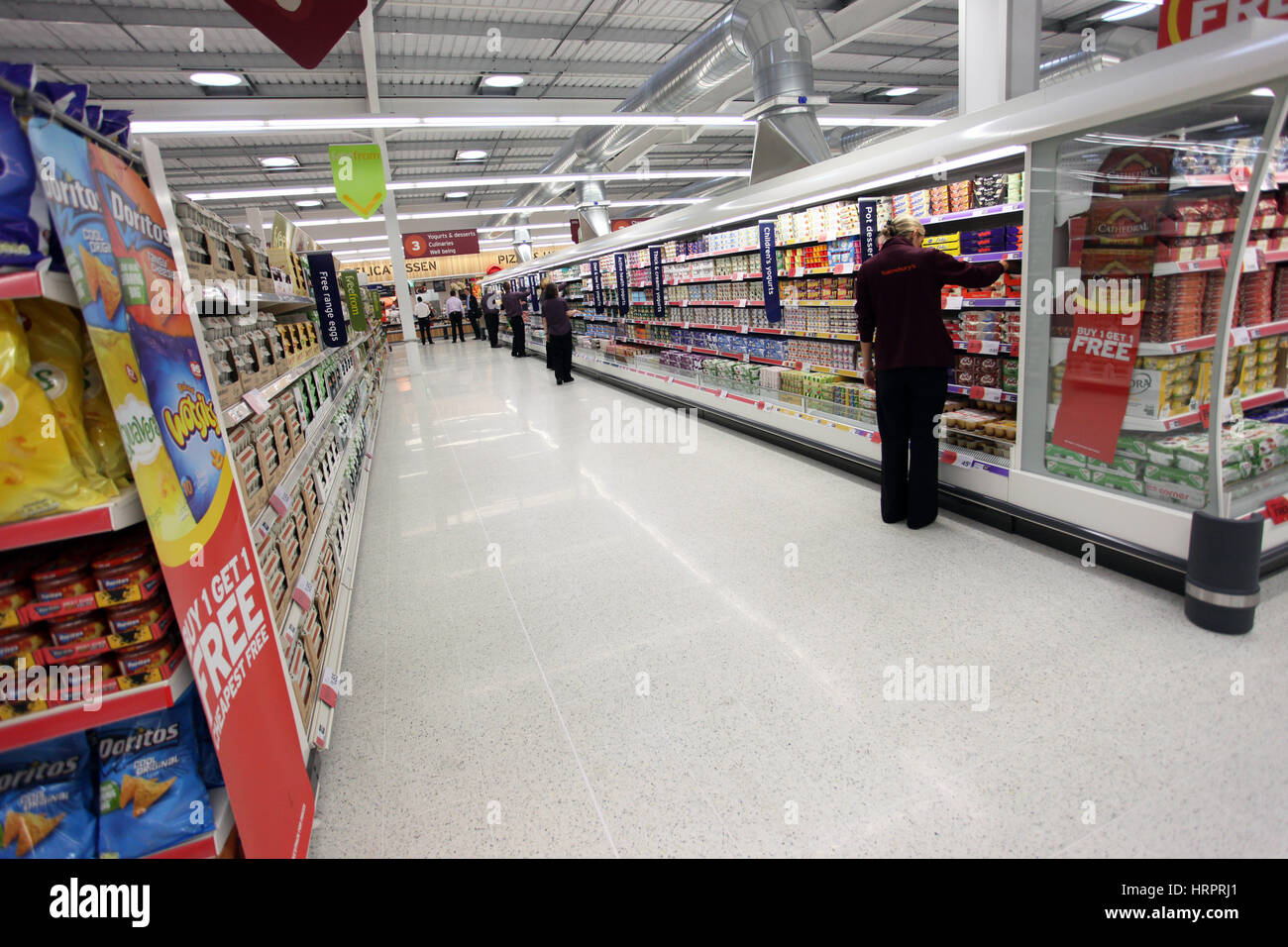 Sainsburys Supermarkt in Colne, Großbritannien. Einer Arbeitnehmerin auf den Gängen Stockfoto