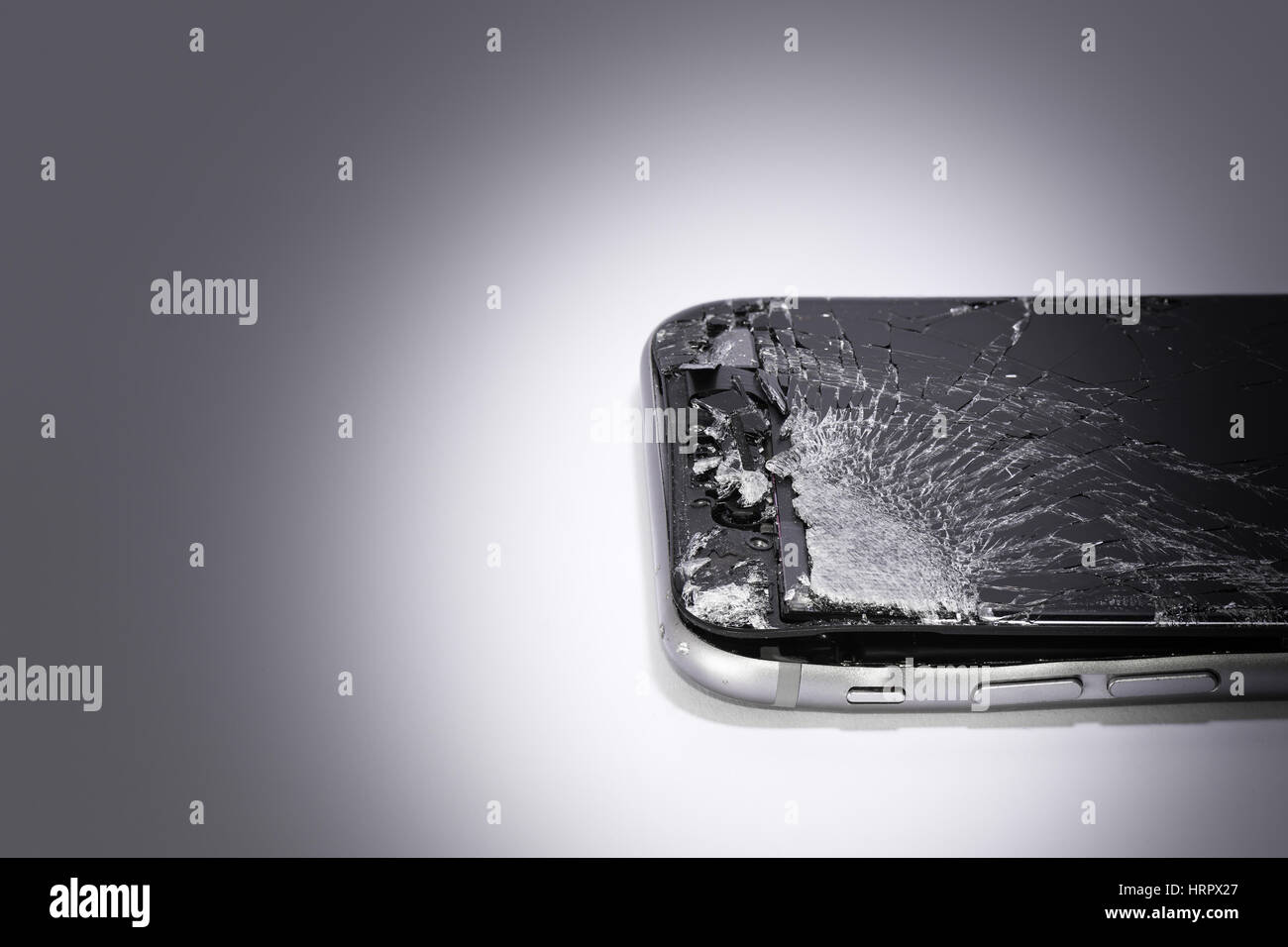 ein Handy mit gebrochenen Bildschirm auf einem Farbverlauf Hintergrund Stockfoto