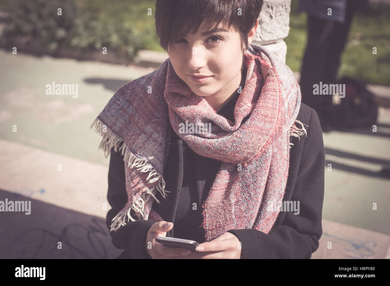 Junge schöne Frau Outdoor-Porträt im sonnigen Tag mit Blick in die Kamera Handy Stockfoto