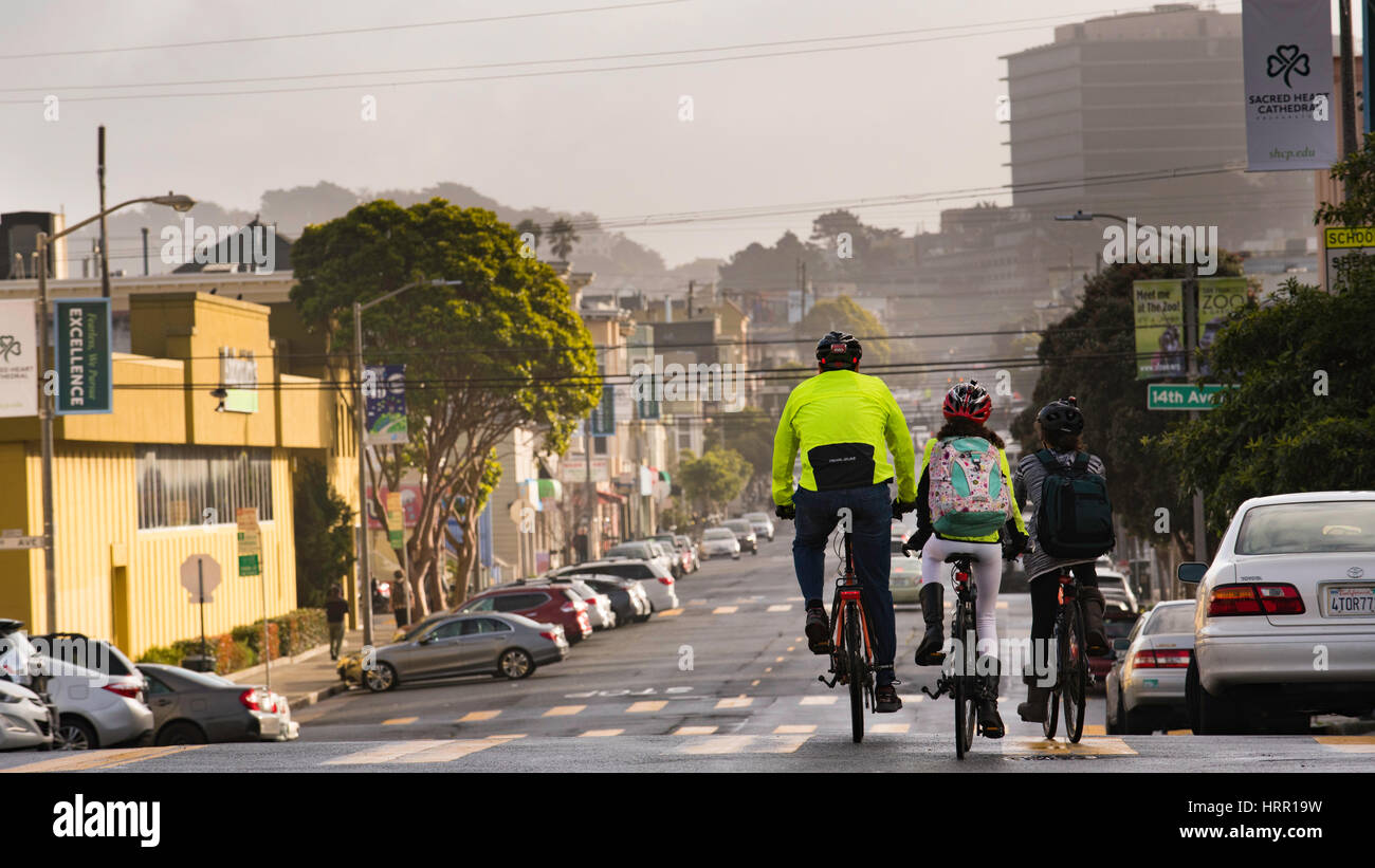 Ein Vater und Kinder, die am Morgen auf dem Weg zum Hotel Fahrrad fahren, fahren im Inner Sunset District von San Francisco, CA, Kalifornien, USA Stockfoto