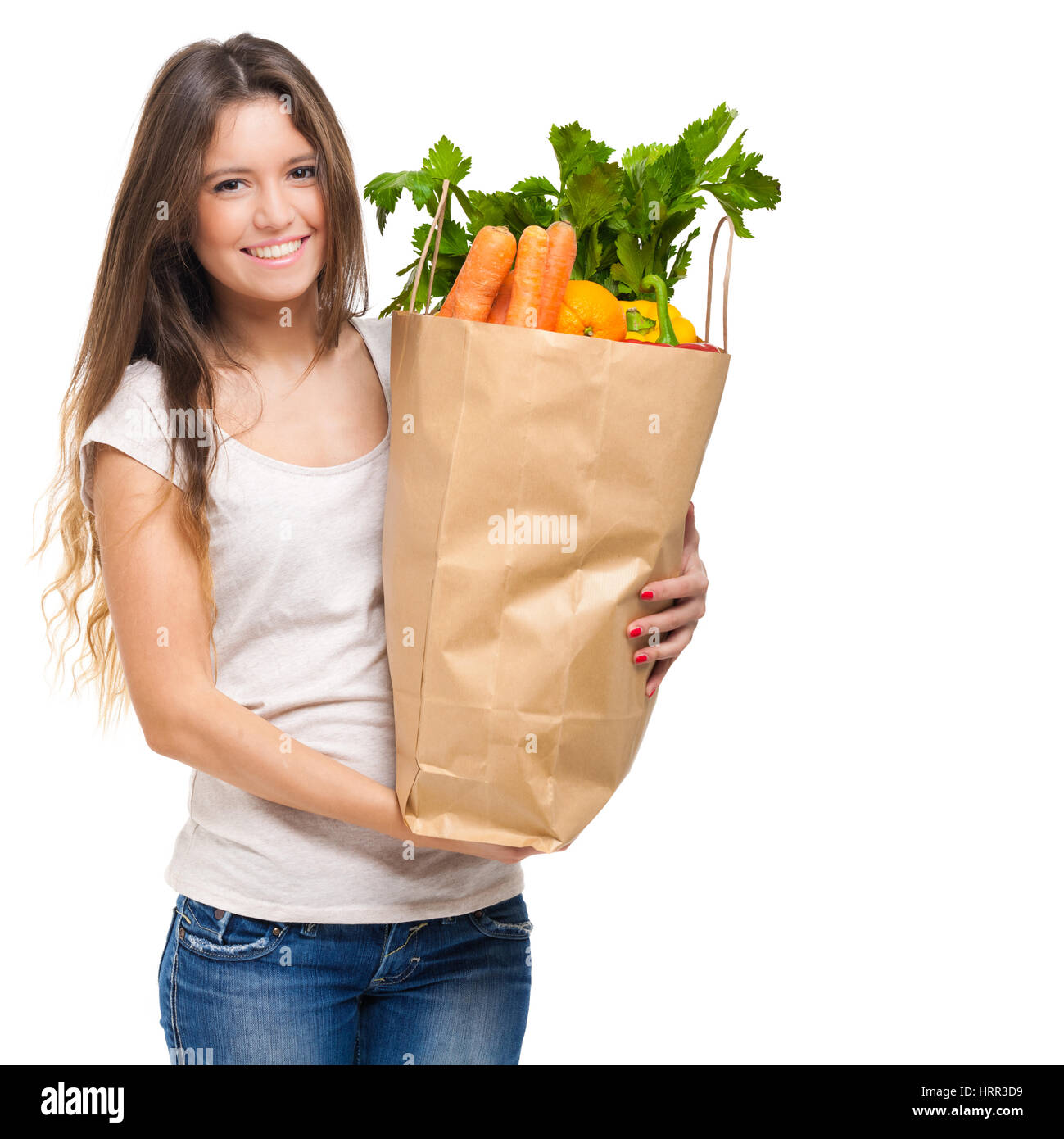 Junge Frau hält eine Einkaufstüte voll mit Gemüse Stockfoto