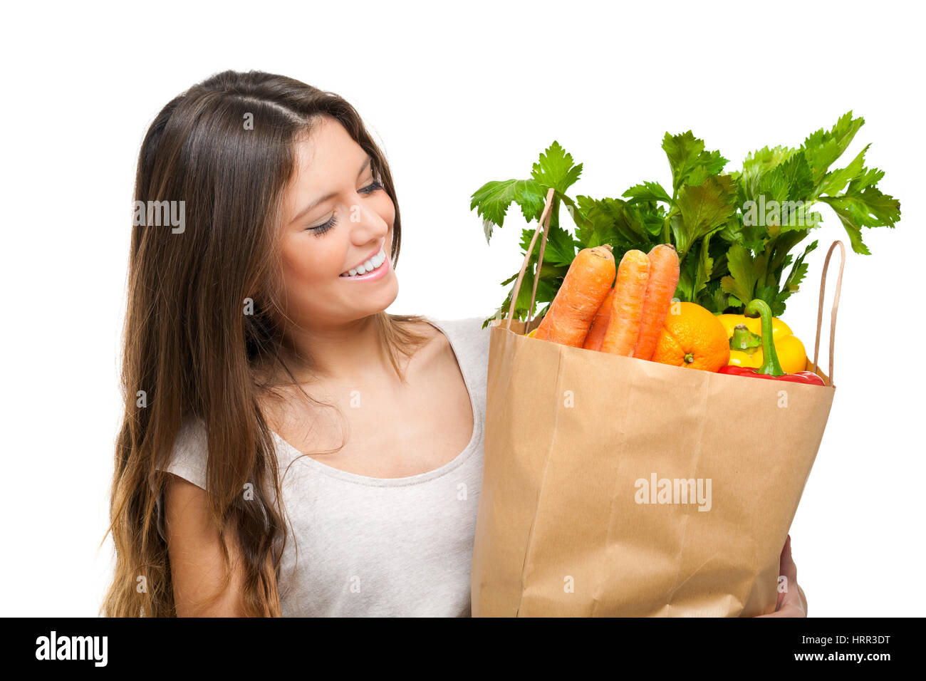 Junge Frau hält eine Einkaufstüte voll mit Gemüse Stockfoto