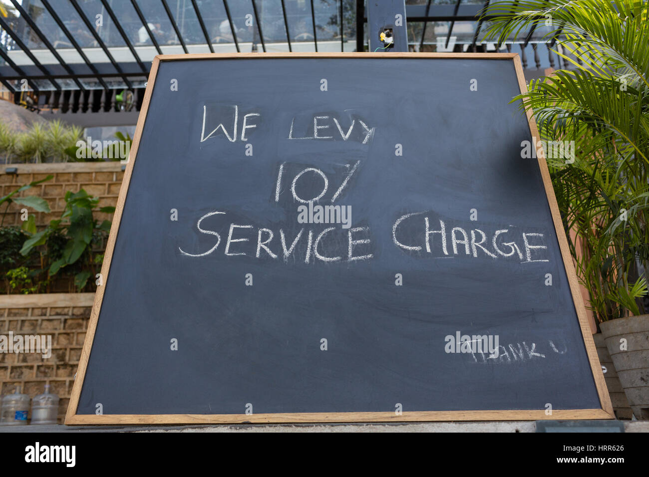 Eine Tafel mit dem Text im Voraus-erheben wir 10 % Servicegebühren befindet sich außerhalb eine beliebte & Bar in Hyderabad, Indien Stockfoto