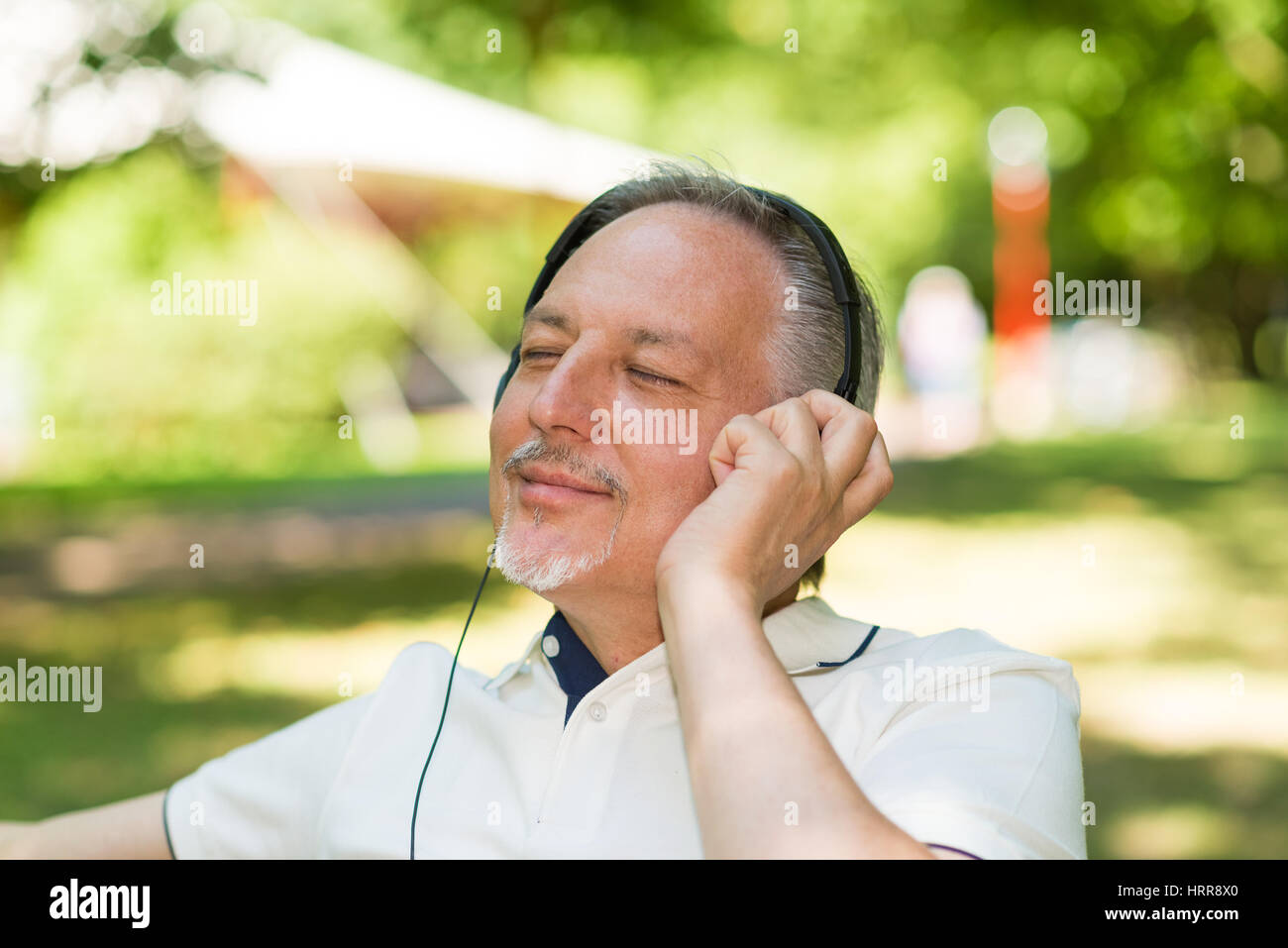 Porträt einer Reifen lächelnden Mann Musik hören im freien Stockfoto