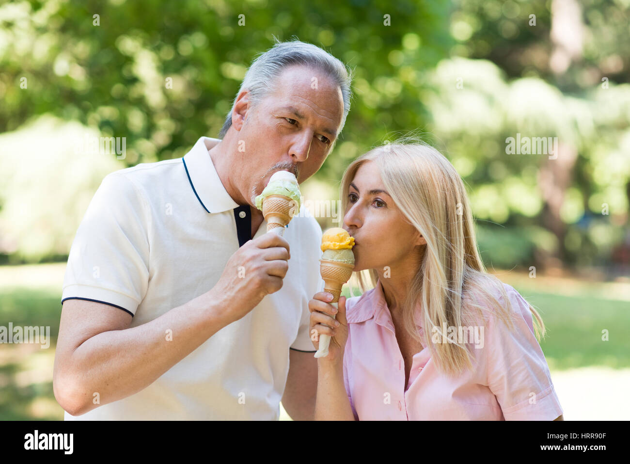 Porträt einer glücklich älteres paar Essen ein Eis in einem park Stockfoto