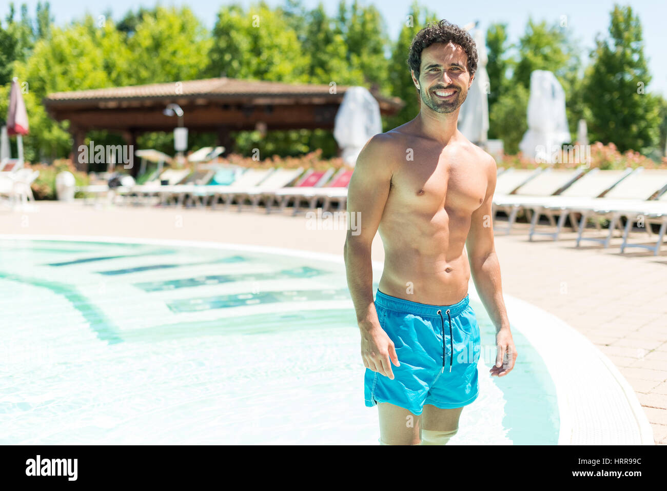 Lächelnd Mann zeigt seinen perfekten Körper während des Urlaubs Stockfoto