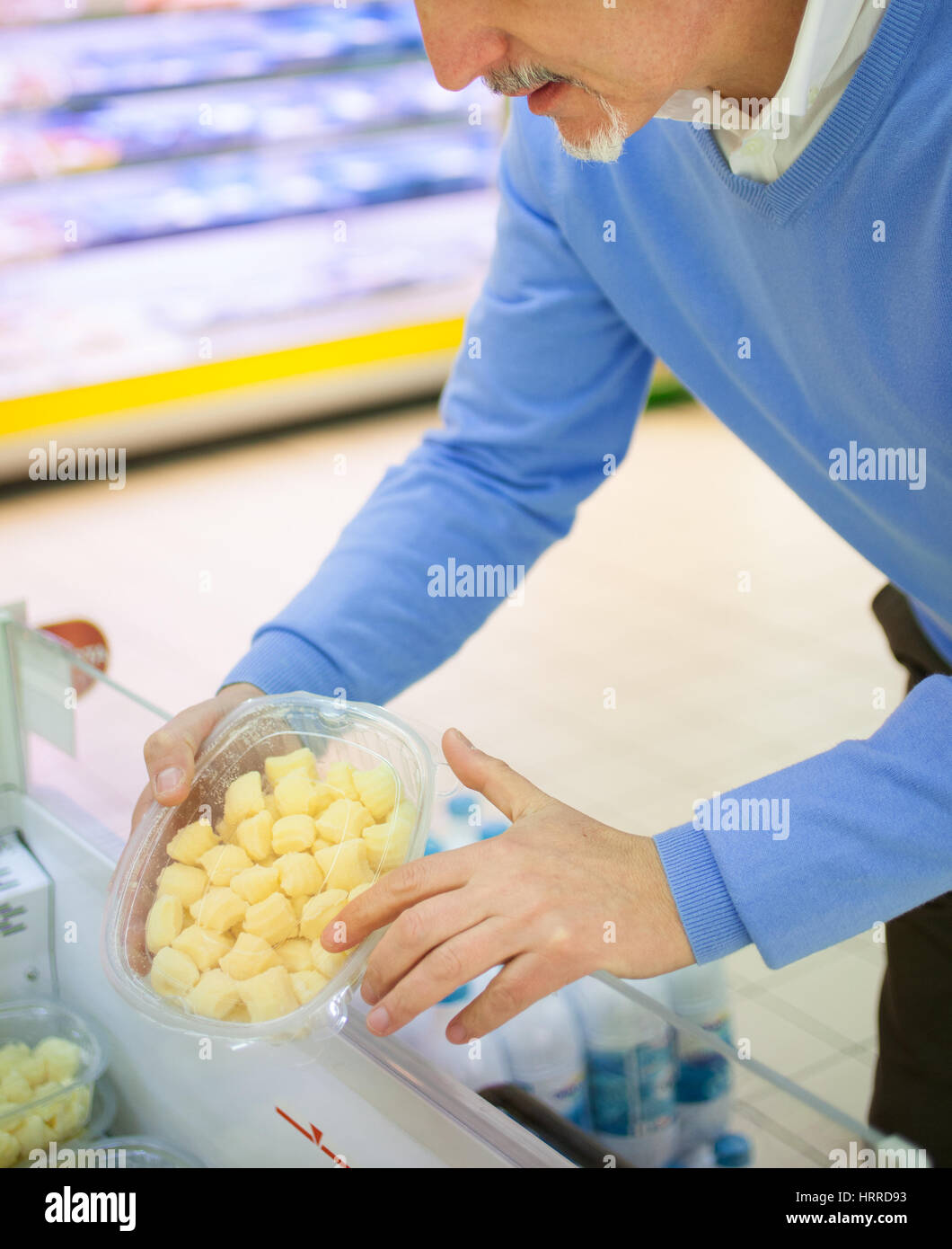 Mann, Abholung Kartoffelknödel in einem Lebensmittelgeschäft Stockfoto