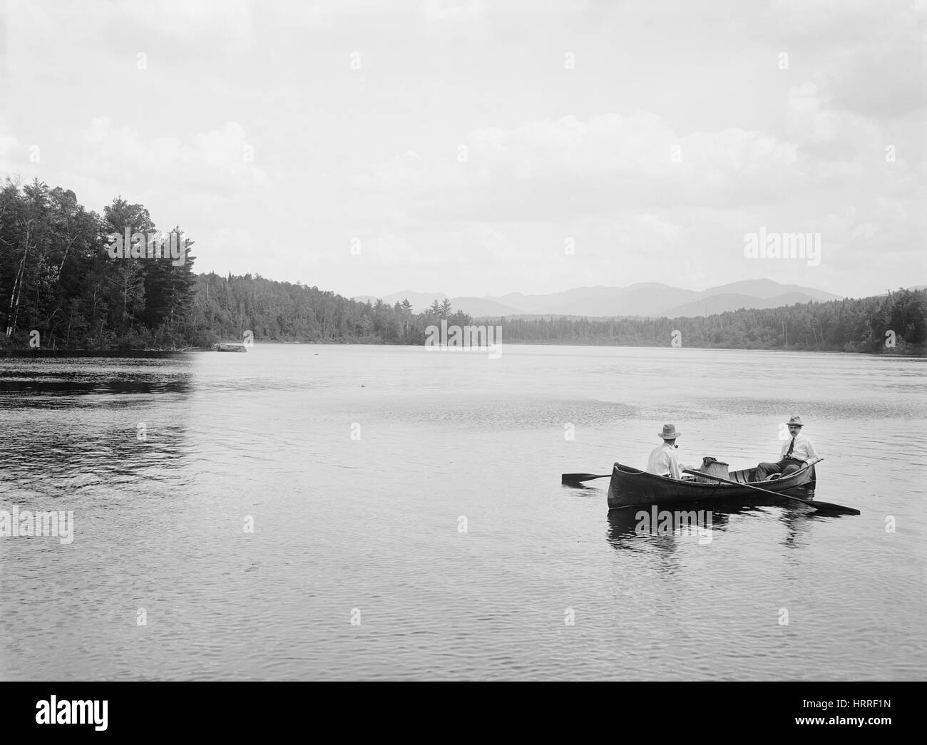 Zwei Männer im Kanu auf See, Adirondack Mountains, New York, USA, William Henry Jackson für Detroit Verlag, 1902 Stockfoto