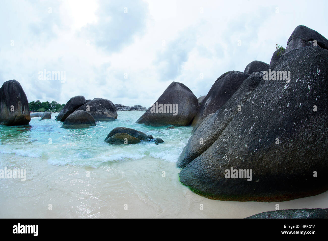 Natürliche schwarze Felsformation am Meer am Strand in Insel Belitung tagsüber, Indonesien. Stockfoto