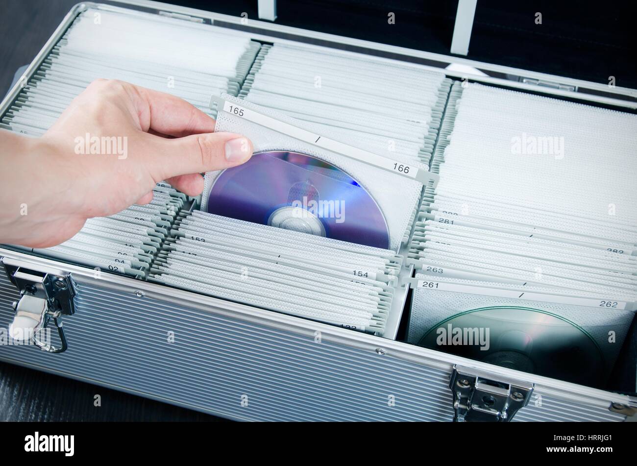 Hand zieht Scheibe aus Aluminium CD / DVD Koffer Stockfoto