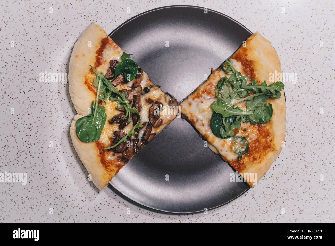 Zwei Scheiben von Pizza in minimalistischem Ambiente Stockfoto