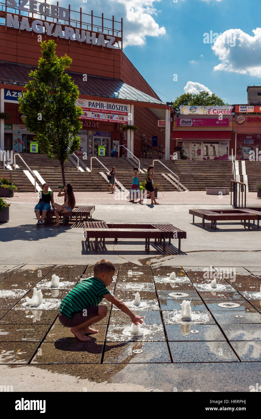 Jungen spielen mit Wasser auf dem Dobó-Platz in Szeged, Ungarn. Stockfoto