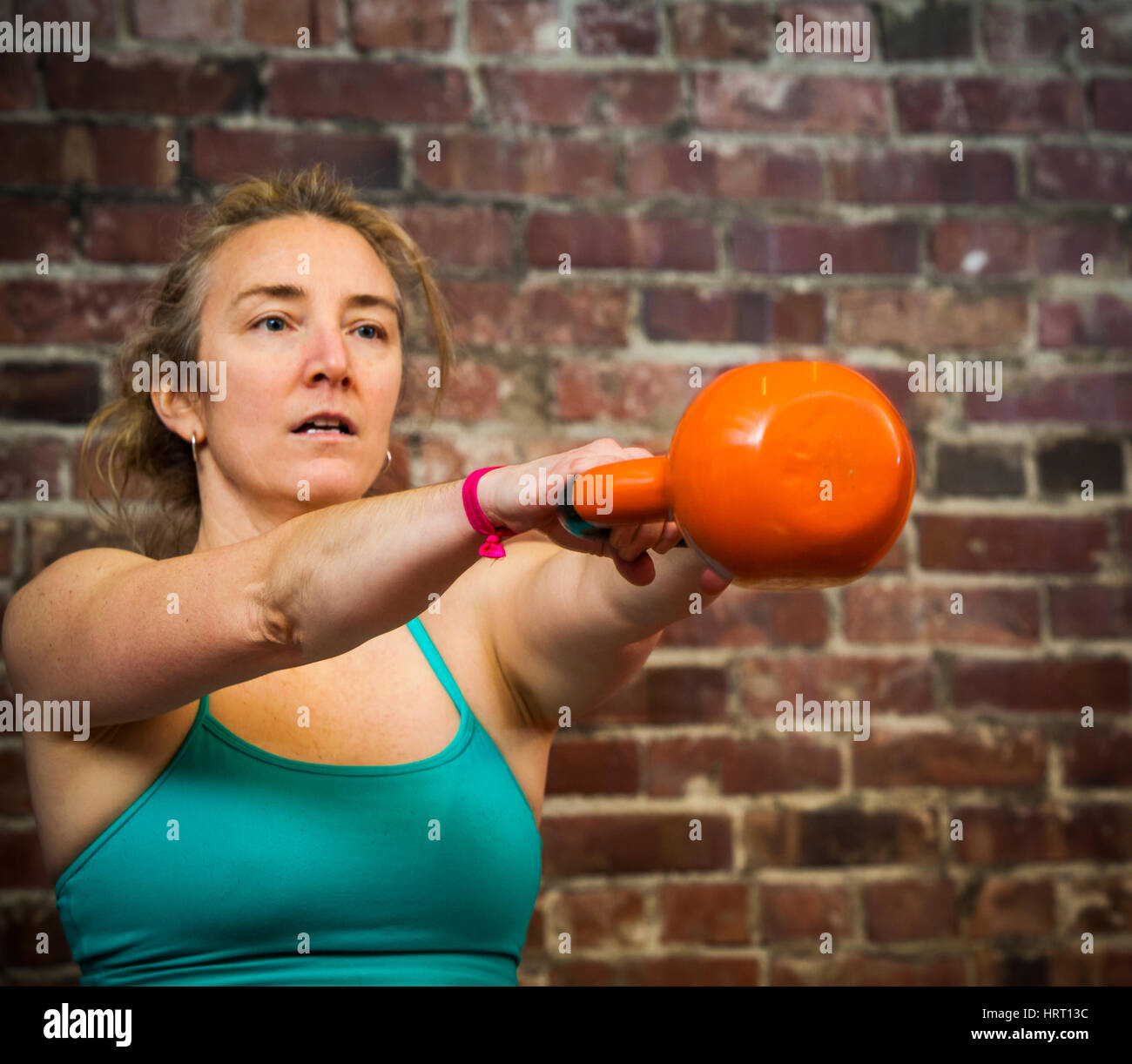Eine Frau in ihrem Anfang 40 ist eine Kettlebell schwingen, während der Arbeit aus. Stockfoto