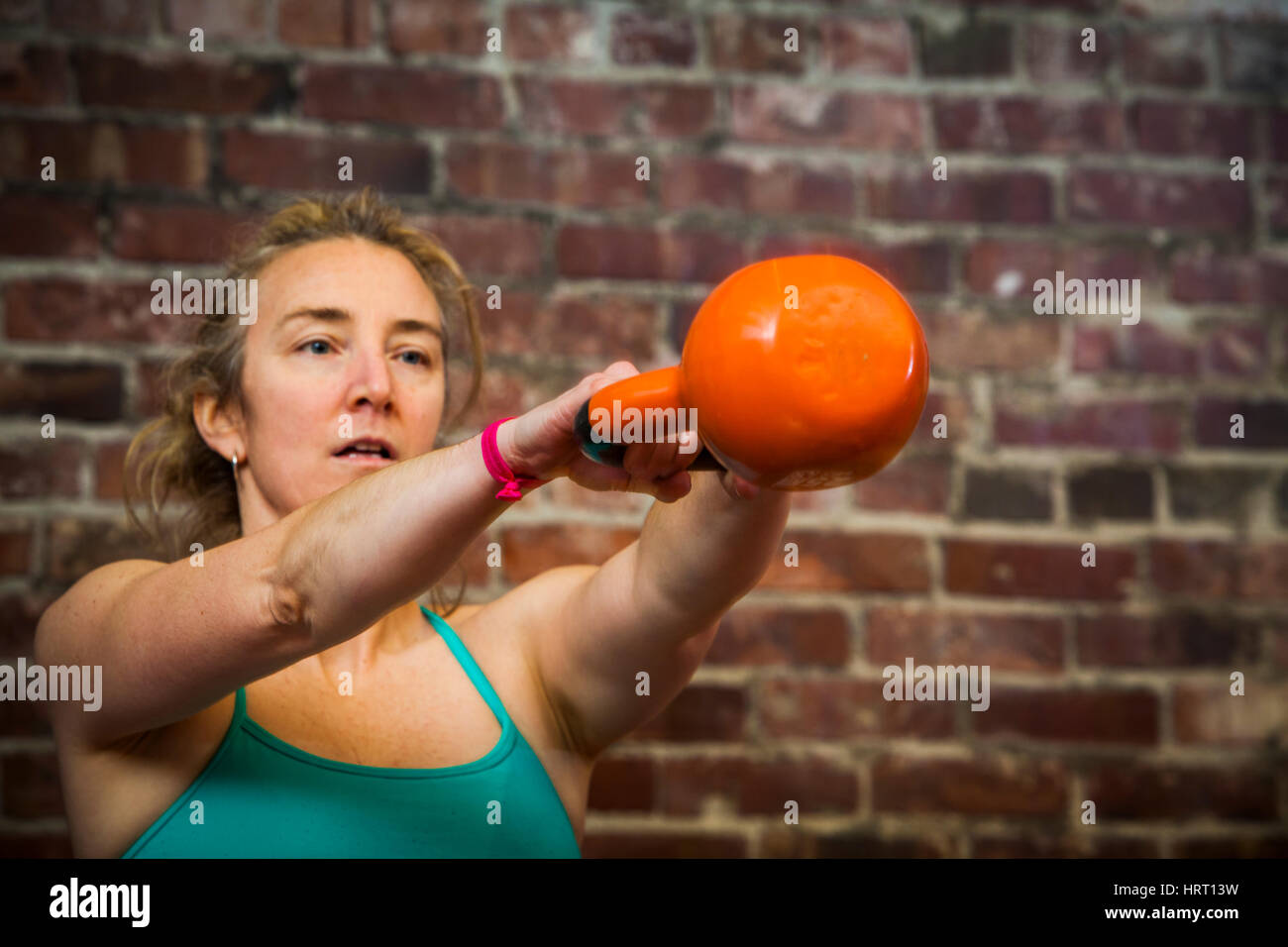 Eine Frau in ihrem Anfang 40 ist eine Kettlebell schwingen, während der Arbeit aus. Stockfoto