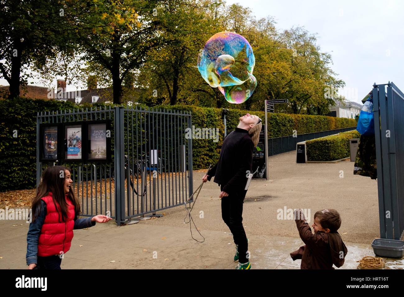 Straße Entertainer oder Straßenmusiker machen riesige Seifenblasen unterhalten Kinder in Greenwich Stockfoto