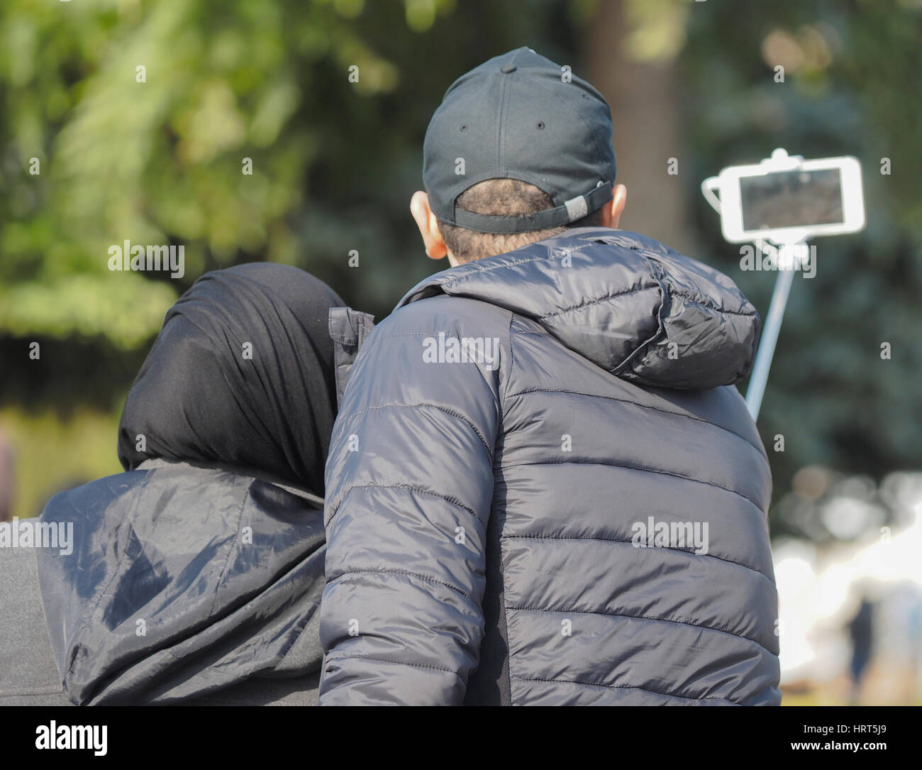 ZWEI TOURISTEN FOTOGRAFIEREN SELFIE PER STICK UND HANDY IN SULTANAHMET GARTEN BEREICH OHR HAGIA SOPHIA ISTANBUL TÜRKEI Stockfoto