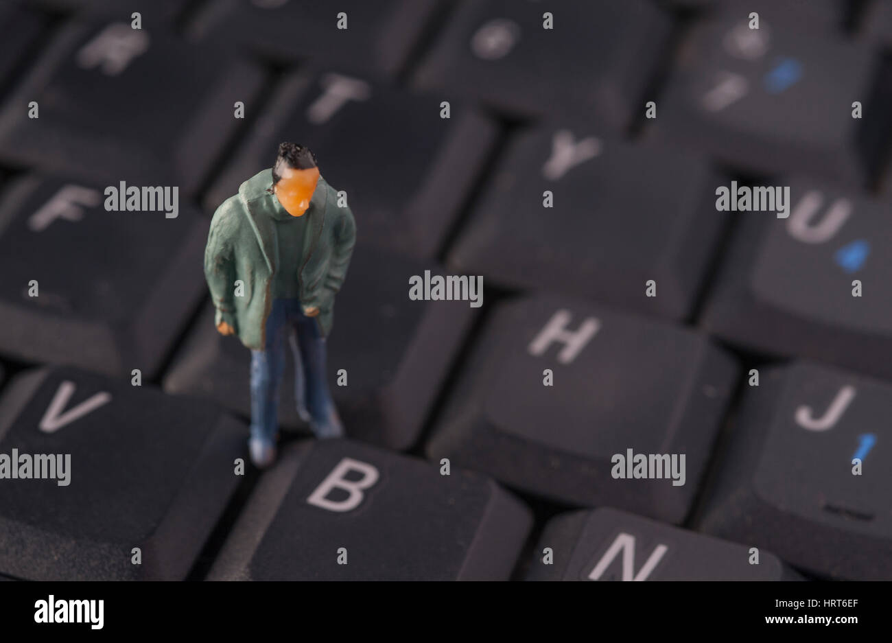 Miniatur männliche Figur tragen Anorak stehend auf Computer-Tastatur Stockfoto