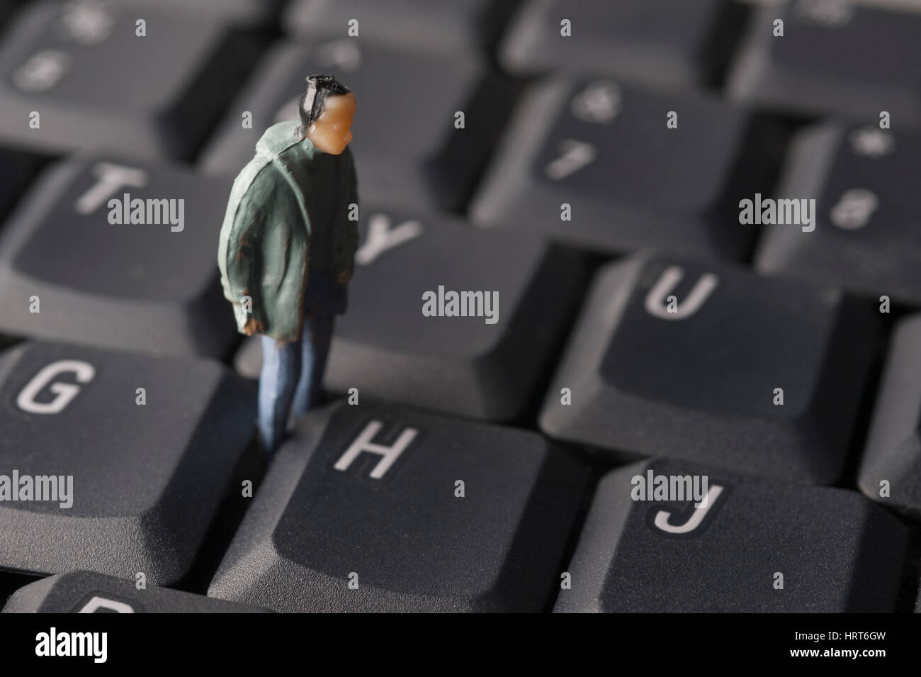 Miniatur männliche Figur tragen Anorak stehend auf Computer-Tastatur Stockfoto