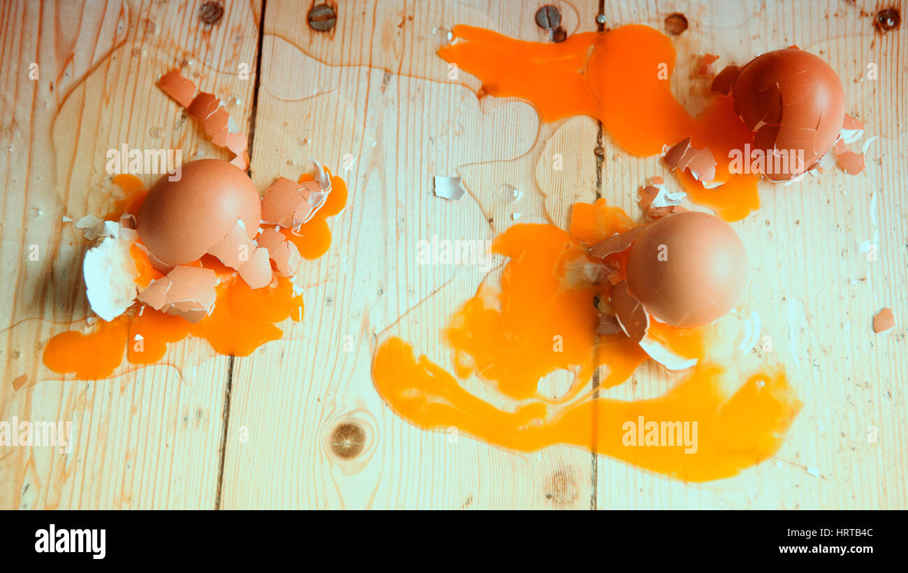 gebrochenen Eiern auf hölzernen flloor Stockfoto