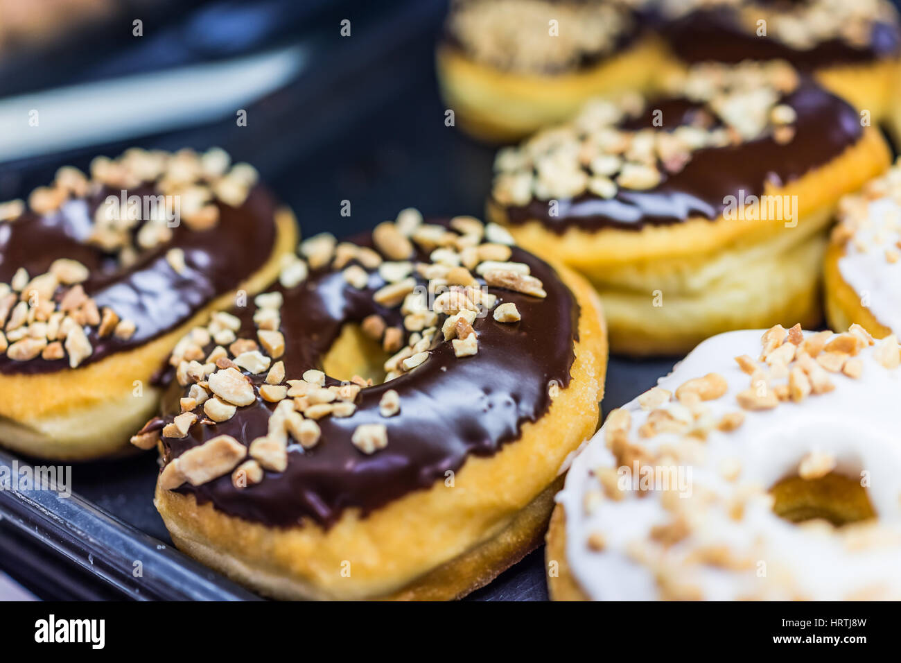 Schokolade Eis Donuts mit gehackten Erdnüssen Stockfoto