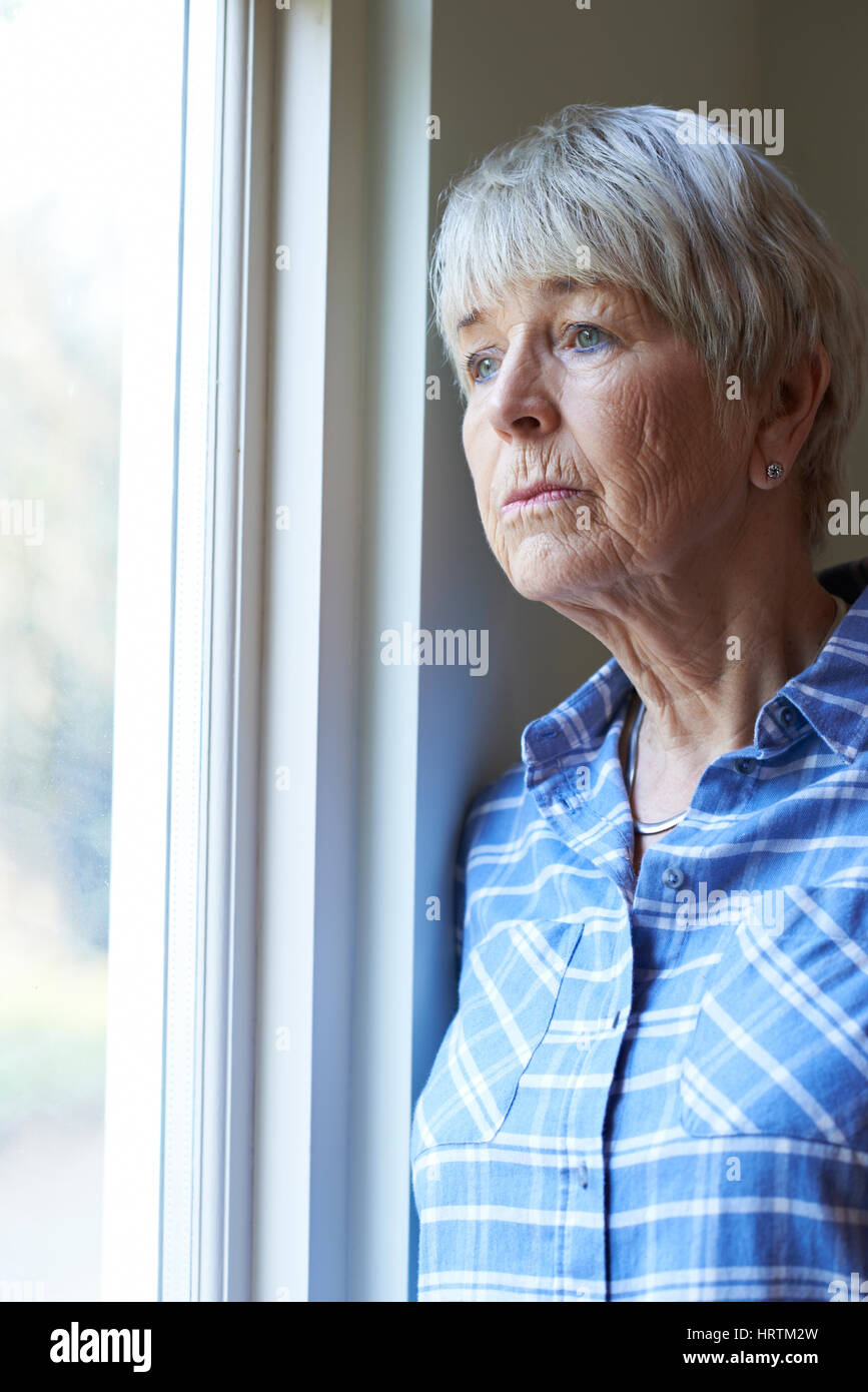 Ältere Frau mit Depressionen Blick aus Fenster Stockfoto